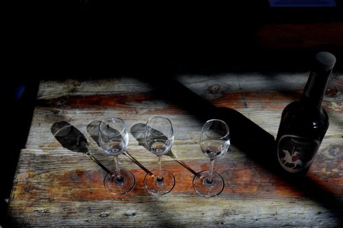 A bottle of Cyprus' famous Commandaria wine sits next to three glasses at the Karseras Winery in the mountain village of Doros on Friday, Feb. 21, 2025. (AP Photo/Petros Karadjias)