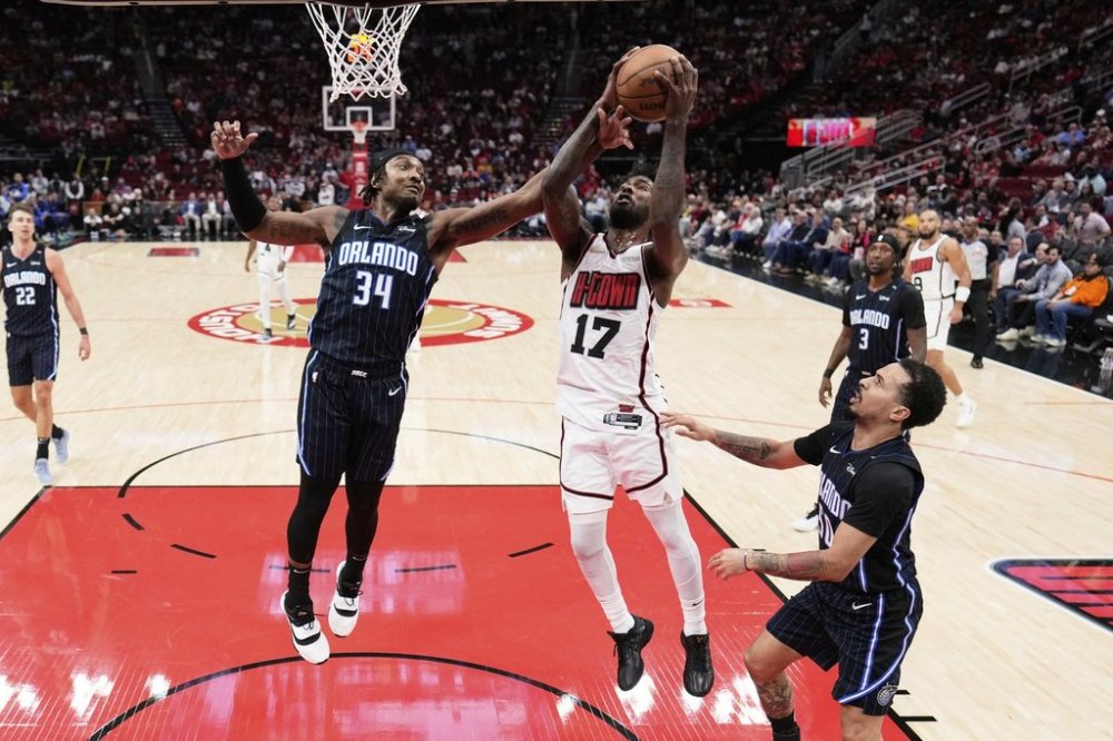 Houston Rockets' Tari Eason (17) and Orlando Magic's Wendell Carter Jr. (34) reach for a rebound during the first half of an NBA basketball game Monday, March 10, 2025, in Houston. (AP Photo/David J. Phillip)