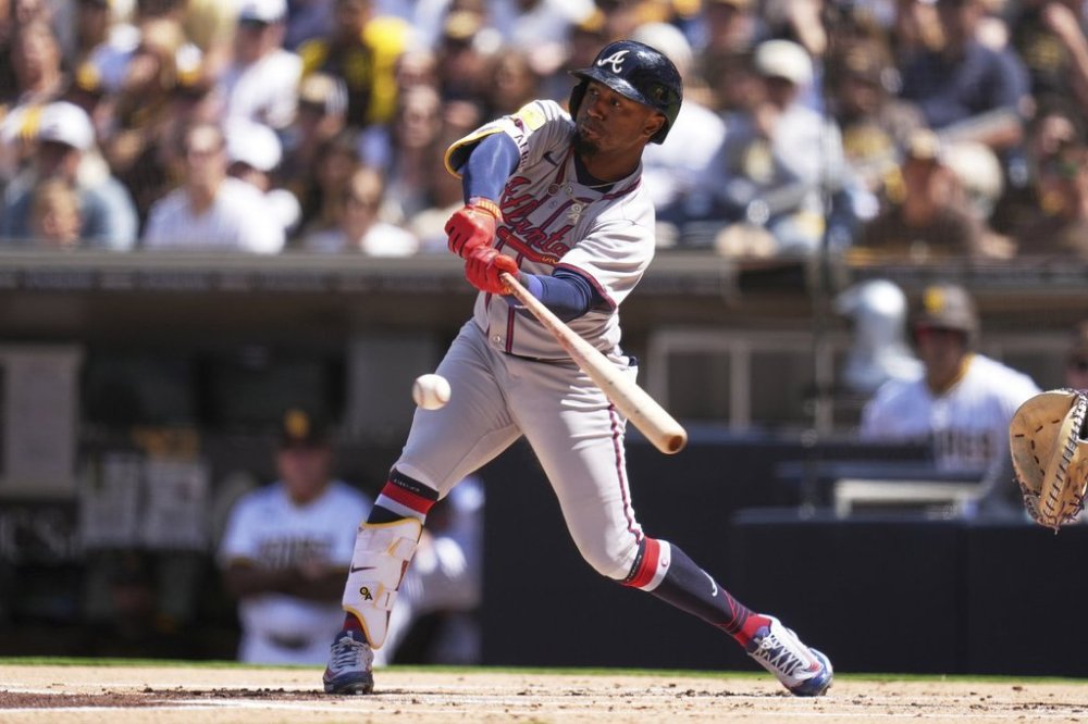 Atlanta Braves' Ozzie Albies hits into a force out during the first inning of an opening-day baseball game against the San Diego Padres Thursday, March 27, 2025, in San Diego. Atlanta Braves' Jurickson Profar scored from third base on the play. (AP Photo/Gregory Bull)
