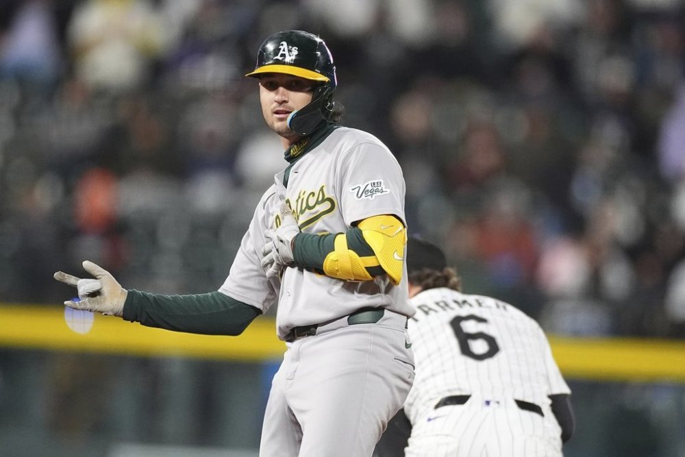 Athletics' Jacob Wilson gestures to the dugout after reaching second base on a double that drove in two runs off Colorado Rockies pitcher Jimmy Herget in the sixth inning of a baseball game Saturday, April 5, 2025, in Denver. (AP Photo/David Zalubowski)
