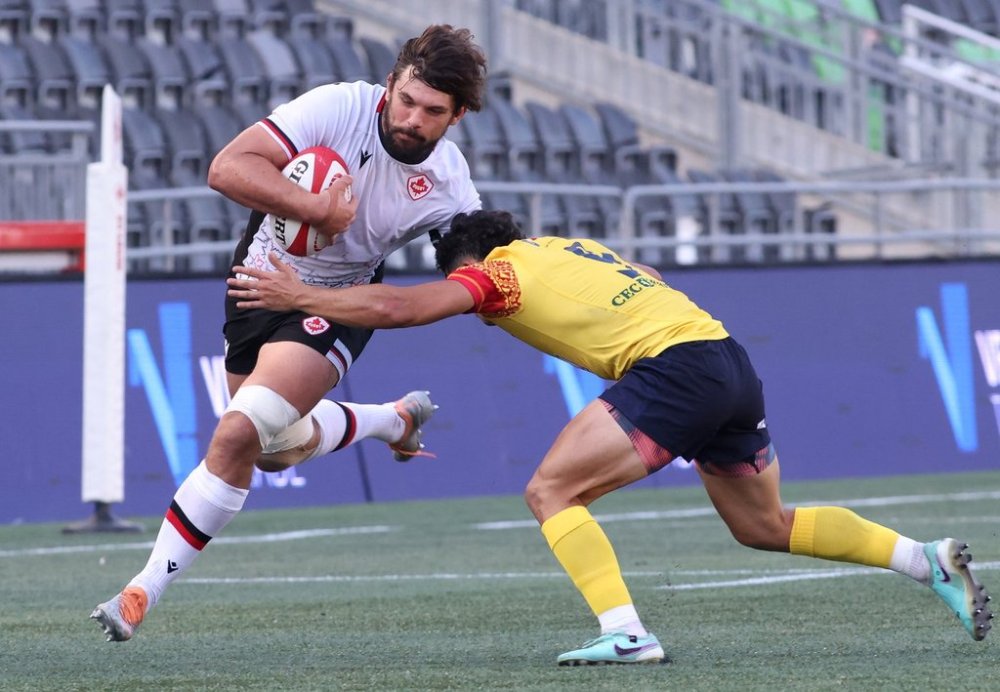 Canada's Lucas Rumball (8) runs with the ball as Romania's Alin Conache (9) tries to tackle him during the first half of men's rugby action in Ottawa on July 12, 2024. THE CANADIAN PRESS/Patrick Doyle