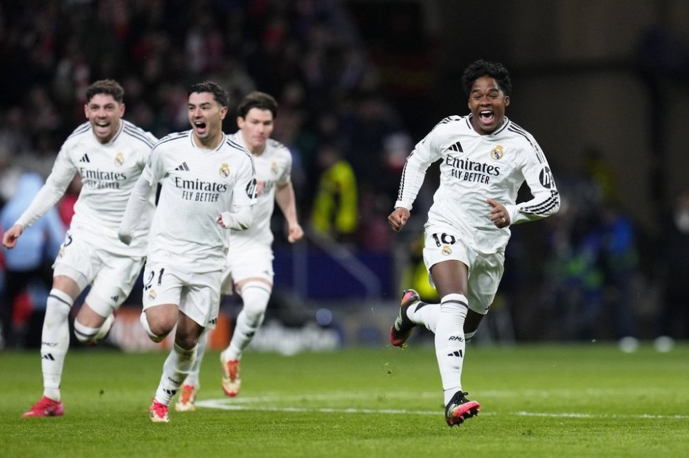 Real Madrid's Endrick, right, and his teammates run celebrating after a penalty shootout at the end of the Champions League round of 16, second leg, soccer match between Atletico Madrid and Real Madrid at the Metropolitano stadium in Madrid, Spain, Wednesday, March 12, 2025. (AP Photo/Manu Fernandez)