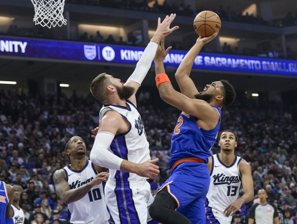 New York Knicks center Karl-Anthony Towns, center right, looks to shoot over Sacramento Kings center Jonas Valanciunas, center left, during the first half of an NBA basketball game in Sacramento, Calif., Monday, March 10, 2025. (AP Photo/Randall Benton)