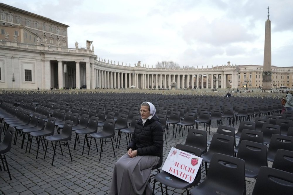 Sister Veronika Mroz, of Poland, sits beside a placard with a picture of Pope Francis, reading: