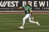 Athletics right fielder Lawrence Butler shouts runs to catch a fly ball hit by Cincinnati Reds' Jeimer Candelario during the second inning of a spring training baseball game, Friday, Feb. 28, 2025, in Mesa, Ariz. (AP Photo/Carolyn Kaster)