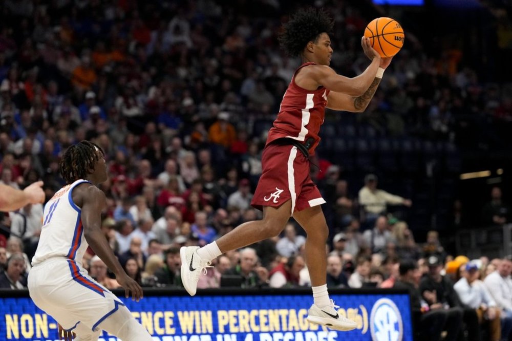 Alabama guard Aden Holloway (2) passes the ball against Florida guard Denzel Aberdeen (11) during the first half of an NCAA college basketball game in the semifinal round of the Southeastern Conference tournament, Saturday, March 15, 2025, in Nashville, Tenn. (AP Photo/George Walker IV)