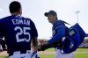Los Angeles Dodgers' Shohei Ohtani, right, of Japan, smiles as he leaves the game with Dodgers' Tommy Edman (25) during the sixth inning of a spring training baseball game against the Texas Rangers Thursday, March 6, 2025, in Phoenix. (AP Photo/Ross D. Franklin)