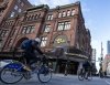 People cycle past the Hudson's Bay department store in downtown Montreal on Monday, March 17, 2025. THE CANADIAN PRESS/Christinne Muschi