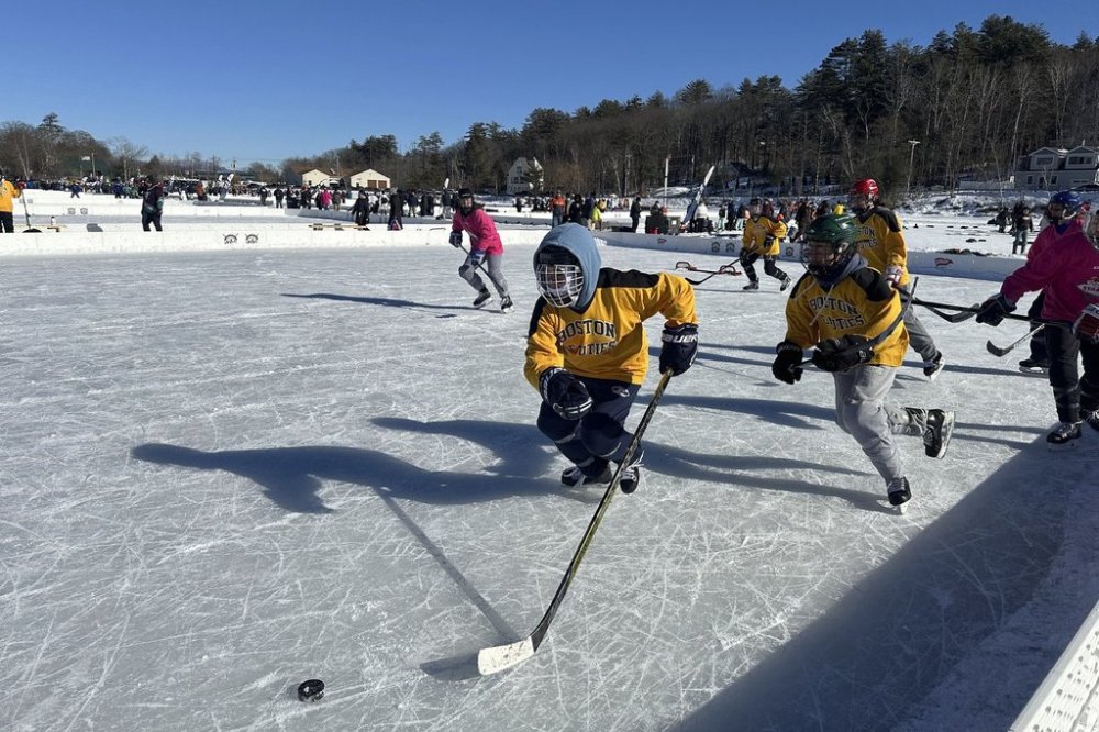 FILE - Hockey players go for the puck during the final of the women's open division at the pond hockey classic in Meredith, N.H., on Sunday, Feb. 4, 2024. (AP Photo/Nick Perry, File)
