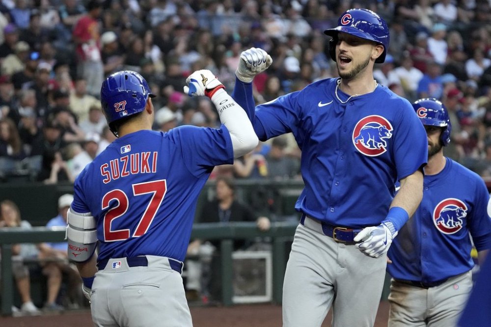 Chicago Cubs outfielder Kyle Tucker, right, gets a forearm bump from Seiya Suzuki (27) after after hitting a two-run home run against the Arizona Diamondbacks during the fifth inning of a baseball game Saturday, March 29, 2025, in Phoenix. (AP Photo/Darryl Webb)