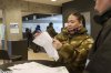 A woman reads her ballot during an early voting for Greenlandic parliamentary elections at the city hall in Nuuk, Greenland, Monday, March 10, 2025. (AP Photo/Evgeniy Maloletka)
