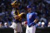 Chicago Cubs' Kyle Tucker scores on a base hit by Michael Busch as Milwaukee Brewers catcher Jorge Alfaro looks away during the first inning of a spring training baseball game, Tuesday, March 11, 2025, in Mesa, Ariz. (AP Photo/Matt York)