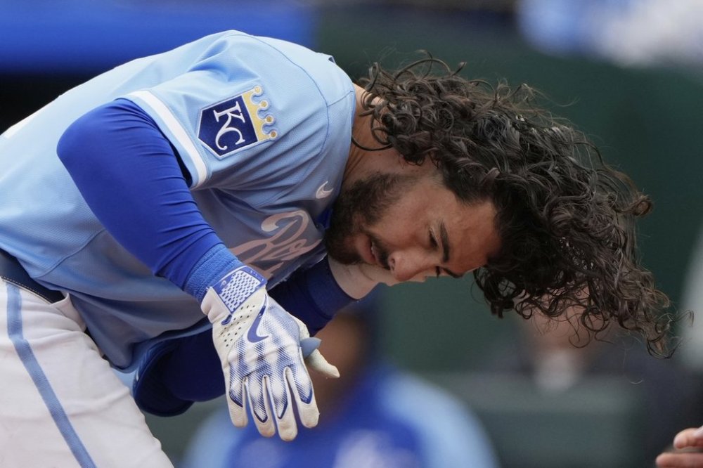 Kansas City Royals' Jonathan India, holds his jaw after he was hit by a pitch thrown by Cleveland Guardians relief pitcher Emmanuel Clase during the ninth inning of a baseball game, Sunday, March 30, 2025, in Kansas City, Mo. (AP Photo/Charlie Riedel)