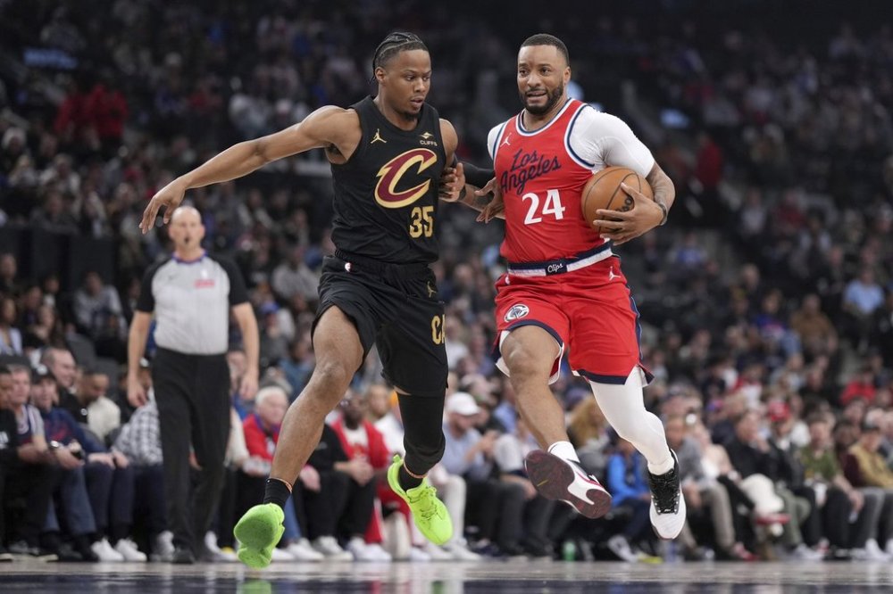Los Angeles Clippers guard Norman Powell, right, drives past Cleveland Cavaliers forward Isaac Okoro during the first half of an NBA basketball game Tuesday, March 18, 2025, in Inglewood, Calif. (AP Photo/Mark J. Terrill)