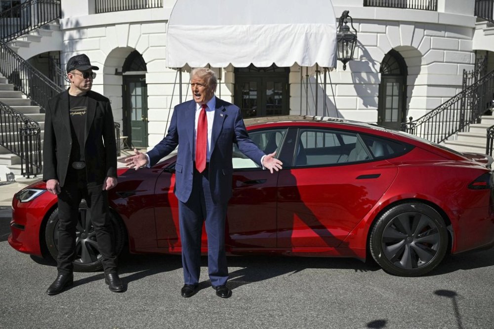 President Donald Trump and Tesla CEO Elon Musk speak to reporters near a red Model S Tesla vehicle on the South Lawn of the White House Tuesday, March 11, 2025, in Washington. THE CANADIAN PRESS/Pool via AP