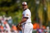 FILE - Baltimore Orioles starting pitcher Albert Suarez looks back at Pittsburgh Pirates' Nick Yorke on first base before delivering in the first inning of a spring training baseball game, Feb. 22, 2025, in Sarasota, Fla. (AP Photo/Stephanie Scarbrough, File)
