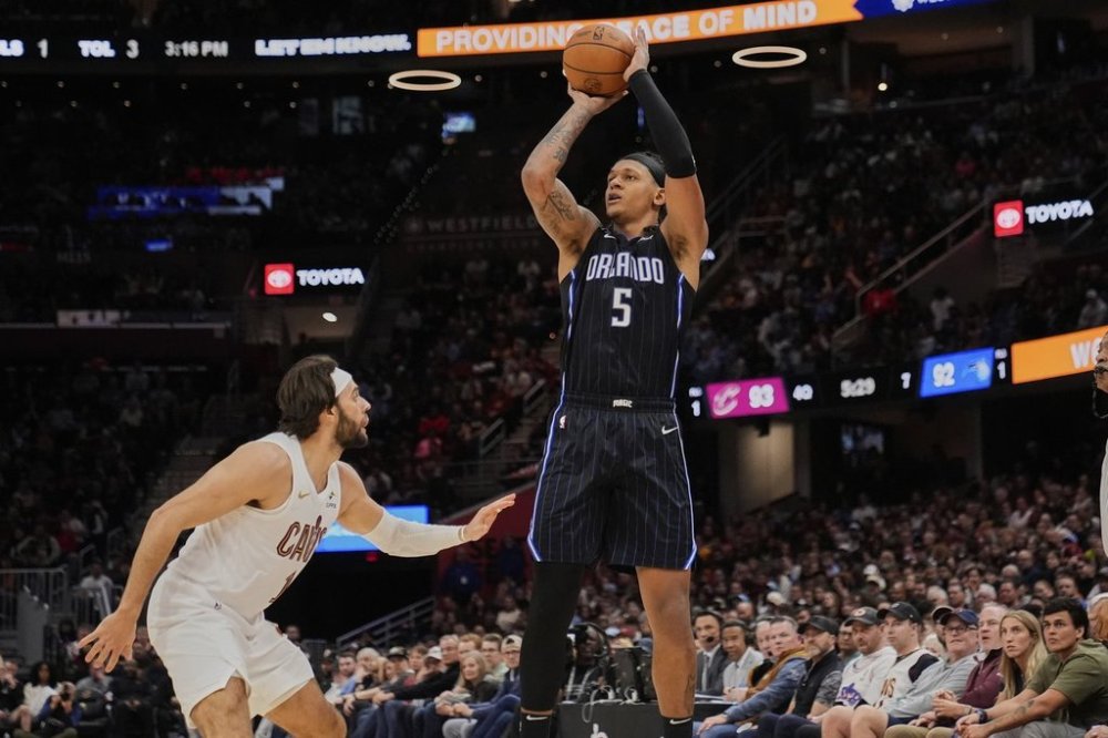 Orlando Magic forward Paolo Banchero (5) shoots over Cleveland Cavaliers guard Max Strus, left, in the second half of an NBA basketball game Sunday, March 16, 2025, in Cleveland. (AP Photo/Sue Ogrocki)