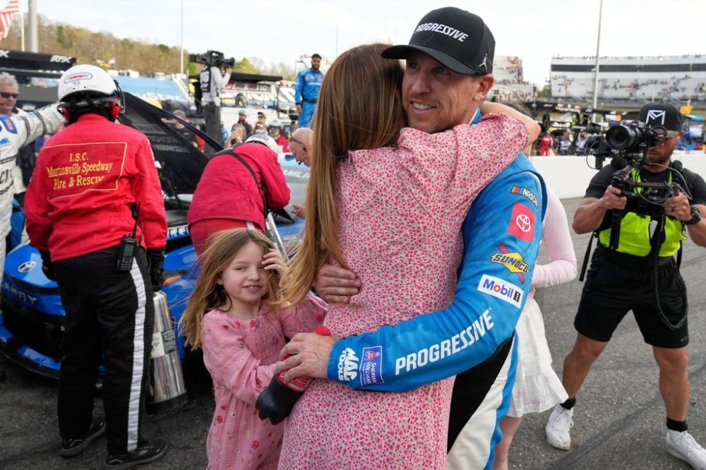 Denny Hamlin, right, hugs his fiance Jordan Fish, left, after winning a NASCAR Cup Series auto race in Martinsville, Va., Sunday, March 30, 2025. (AP Photo/Chuck Burton)