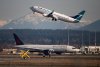 An Air Canada flight departing for Toronto, bottom, taxis to a runway as a WestJet flight bound for Palm Springs takes off at Vancouver International Airport, in Richmond, B.C., on March 20, 2020. THE CANADIAN PRESS/Darryl Dyck