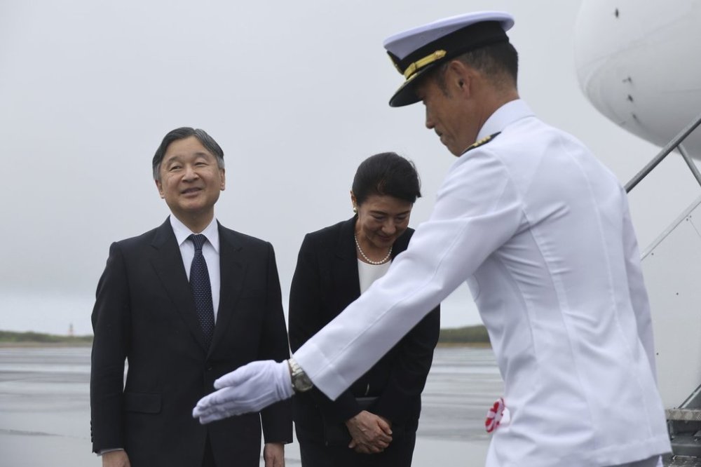 Japanese Emperor Naruhito, left, and Empress Masako, center, are escorted by a member of Japan Self Defense Force as they arrive at the island of Iwo Jima, now officially called Iwo To in Japan, Monday April 7, 2025. (Kim Kyung-Hoon/Pool Photo via AP)
