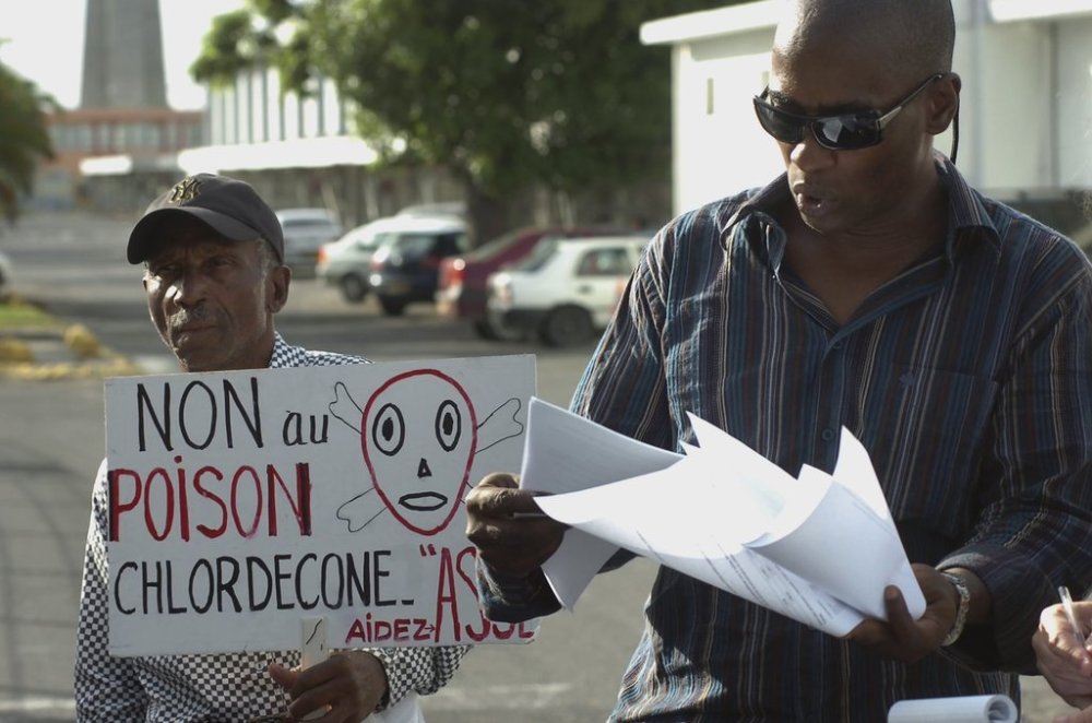 FILE - Lawyer Harry Durimel, right, stands next to an activist with a sign that reads in French