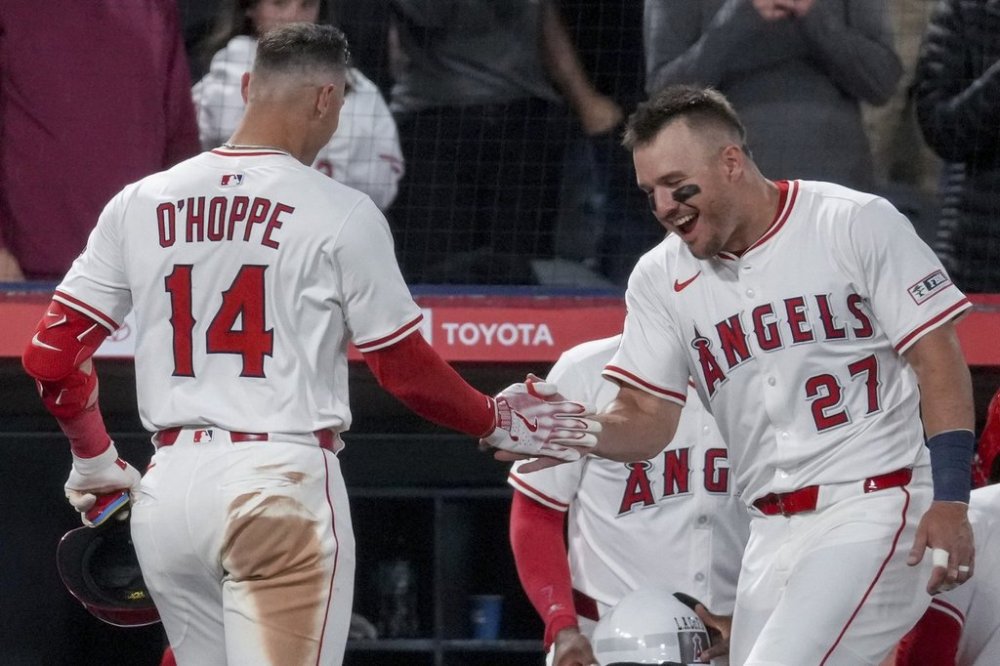 Los Angeles Angels' Mike Trout (27) high fives Logan O'Hoppe (14) during the fifth inning of a baseball game against the Cleveland Guardians in Anaheim, Calif., Saturday, April 5, 2025. (AP Photo/Eric Thayer)