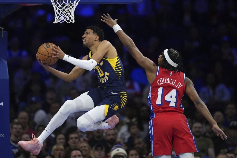 Indiana Pacers' Tyrese Haliburton, left, goes up for a shot agaist Philadelphia 76ers' Ricky Council IV during the first half of an NBA basketball game Friday, March 14, 2025, in Philadelphia. (AP Photo/Matt Slocum)