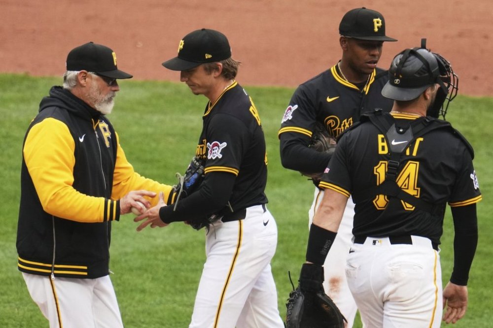 Pittsburgh Pirates pitcher Ryan Borucki, center, hands the ball to manager Derek Shelton, left, during the ninth inning of a baseball game New York Yankees in Pittsburgh, Sunday, April 6, 2025. (AP Photo/Gene J. Puskar)
