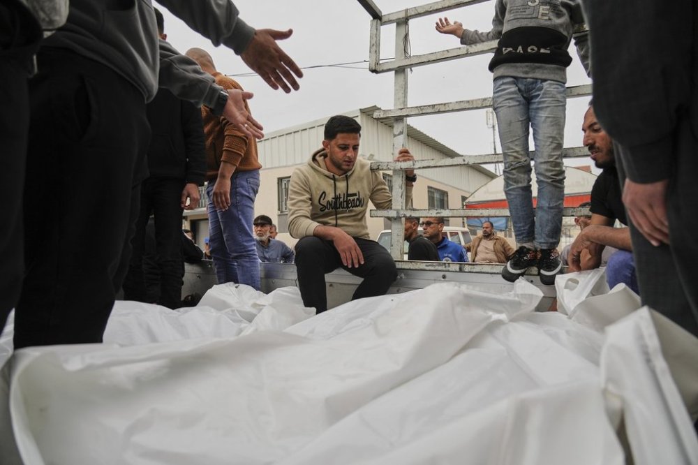 Mourners carry the bodies of three members of Dahouh family, killed when an Israeli army strike hit their tent, before their burial at the hospital in Deir al-Balah, Gaza Strip on Tuesday, April 1, 2025. (AP Photo/Abdel Kareem Hana)