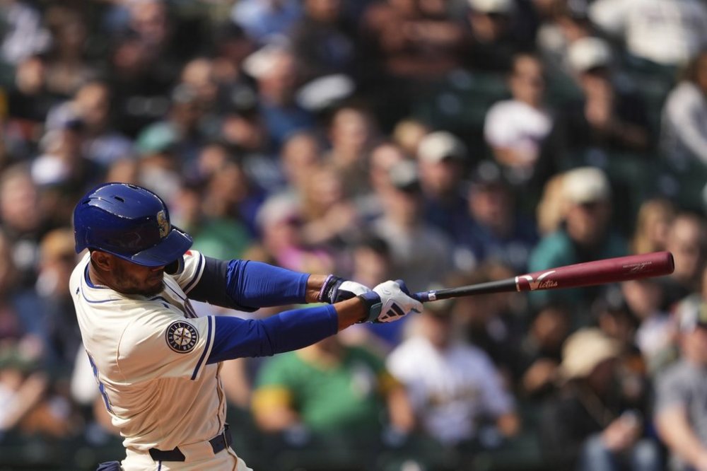 Seattle Mariners' Julio Rodríguez follows through on a two-run home run against the Athletics during the sixth inning of a baseball game Sunday, March 30, 2025, in Seattle. (AP Photo/Lindsey Wasson)