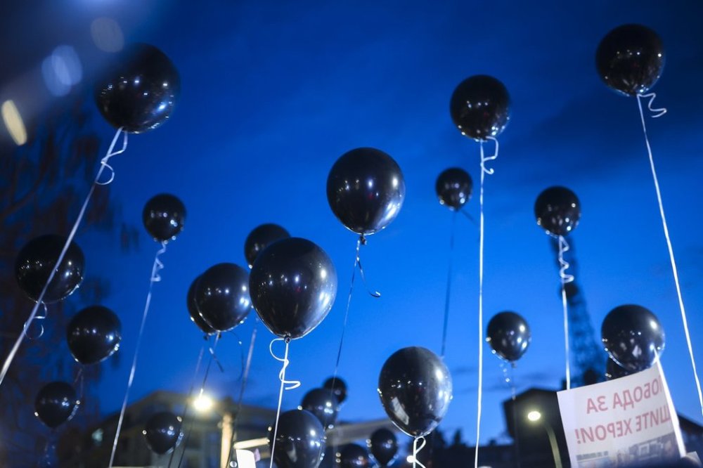 People taking part in a protest hold balloons in the town of Kocani, North Macedonia, Tuesday, March 18, 2025 following a massive fire in a nightclub early SUnday. (AP Photo/Armin Durgut)