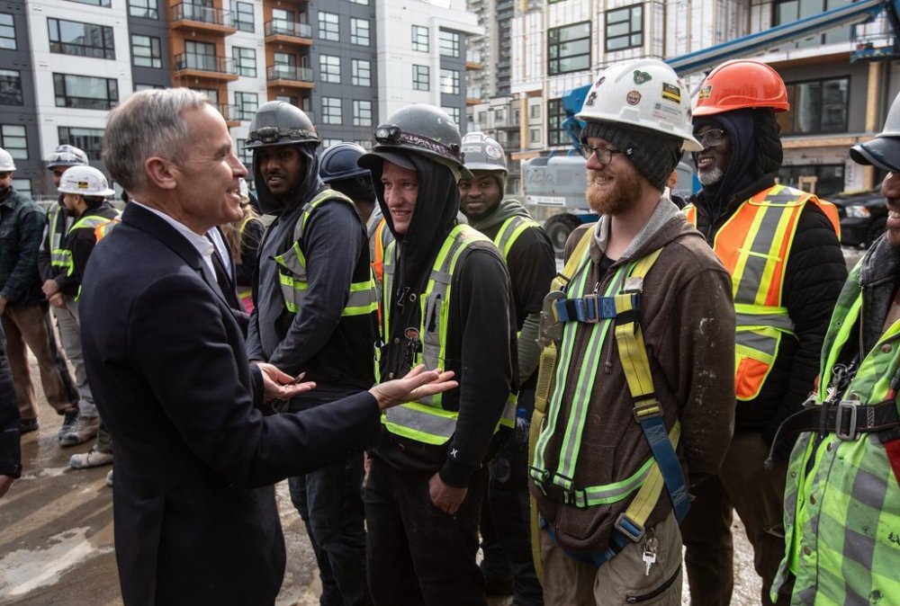 Prime Minister Mark Carney meets with workers after announcing funding for houses during a visit to Edmonton on Thursday, March 20, 2025. THE CANADIAN PRESS/Jason Franson