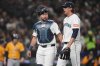 Seattle Mariners catcher Cal Raleigh, left, check on starting pitcher Logan Gilbert after Gilbert was hit by a line drive from Athletics' Lawrence Butler during the third inning of an opening-day baseball game, Thursday, March 27, 2025, in Seattle. (AP Photo/Lindsey Wasson)