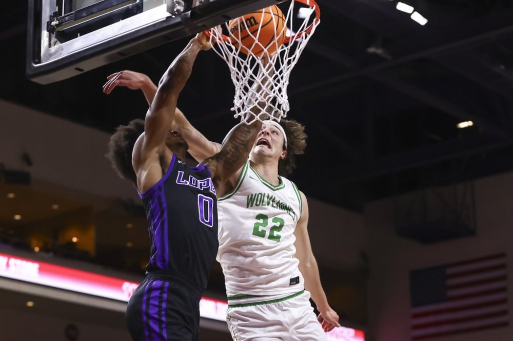 Grand Canyon guard Ray Harrison (0) dunks the ball under pressure from Utah Valley forward Carter Welling (22) during the first half of an NCAA college basketball game in the championship of the Western Athletic Conference tournament Saturday, March 15, 2025, in Las Vegas. (AP Photo/Chase Stevens)