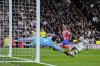 Real Madrid's goalkeeper Thibaut Courtois, left, makes a save in front Atletico Madrid's Antoine Griezmann, center, during the Champions League round of 16 first leg soccer match between Real Madrid and Atletico Madrid at the Bernebeu stadium in Madrid, Spain, Tuesday, March 4, 2025. (AP Photo/Manu Fernandez)