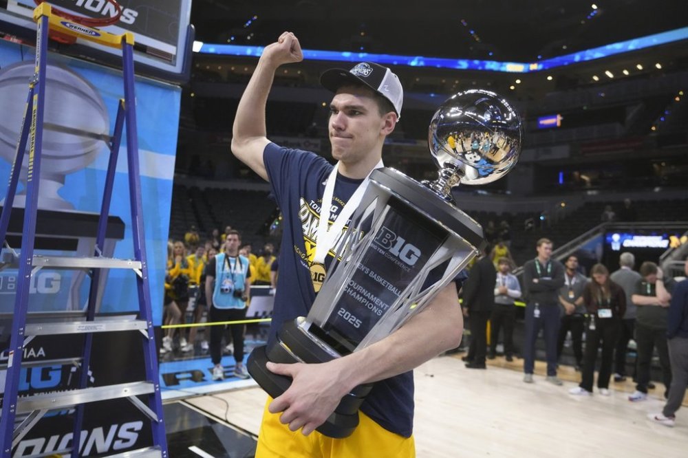 Michigan center Vladislav Goldin (50) carries the trophy after an NCAA college basketball game against Wisconsin in the championship of the Big Ten Conference tournament in Indianapolis, Sunday, March 16, 2025. (AP Photo/Michael Conroy)
