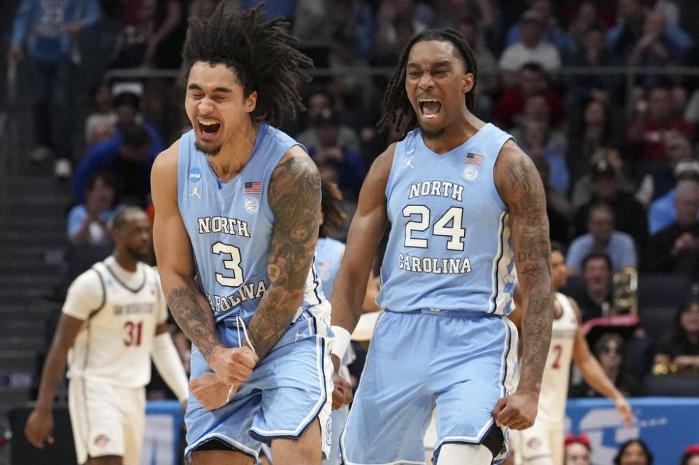 North Carolina's Elliot Cadeau (3) celebrates with teammate Jae'Lyn Withers (24) during the first half of a First Four college basketball game against San Diego State in the NCAA Tournament, Tuesday, March 18, 2025, in Dayton, Ohio. (AP Photo/Jeff Dean)
