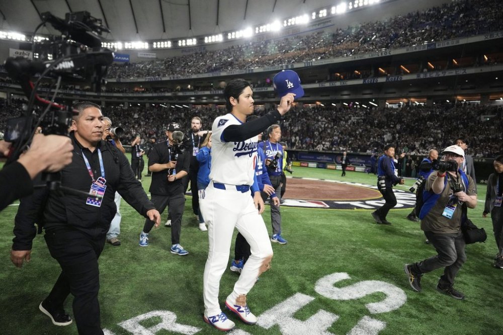 Los Angeles Dodgers' Shohei Ohtani tips his cap as he leaves the field after the team's win against the Chicago Cubs in an MLB Tokyo Series baseball game in Tokyo, Japan, Wednesday, March 19, 2025. (AP Photo/Eugene Hoshiko)