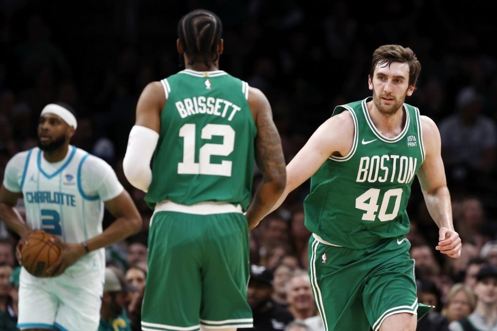 Boston Celtics' Luke Kornet (40) celebrates with Oshae Brissett (12) after scoring during the first half of an NBA game against the Charlotte Hornets on Friday, April 12, 2024, in Boston. (AP Photo/Michael Dwyer)