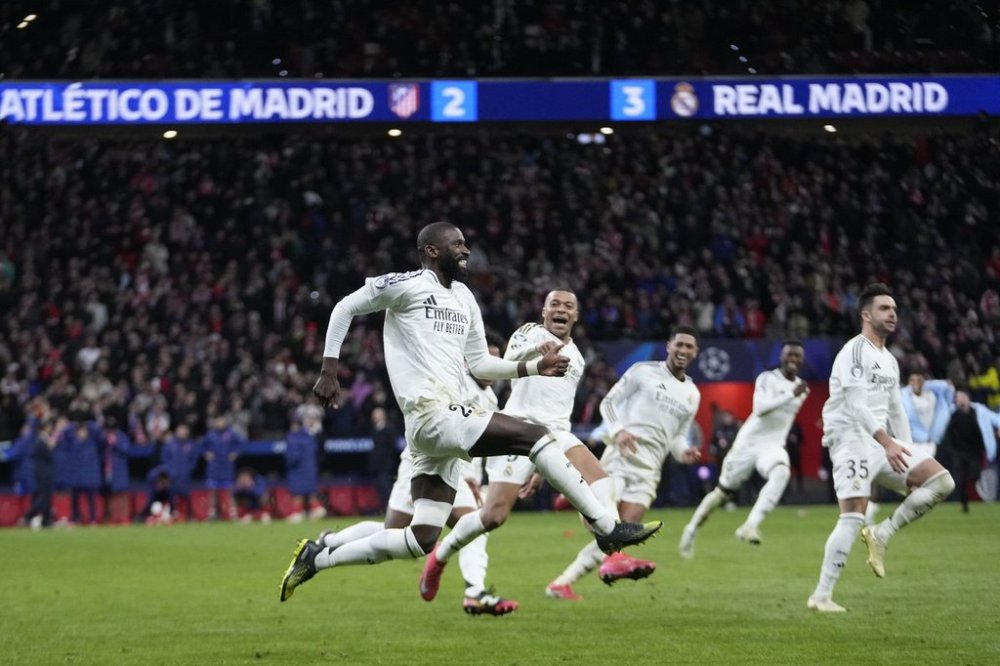 Real Madrid players celebrate after winning the penalty shootout during the Champions League round of 16, second leg, soccer match between Atletico Madrid and Real Madrid at the Metropolitano stadium in Madrid, Spain, Wednesday, March 12, 2025. (AP Photo/Bernat Armangue)