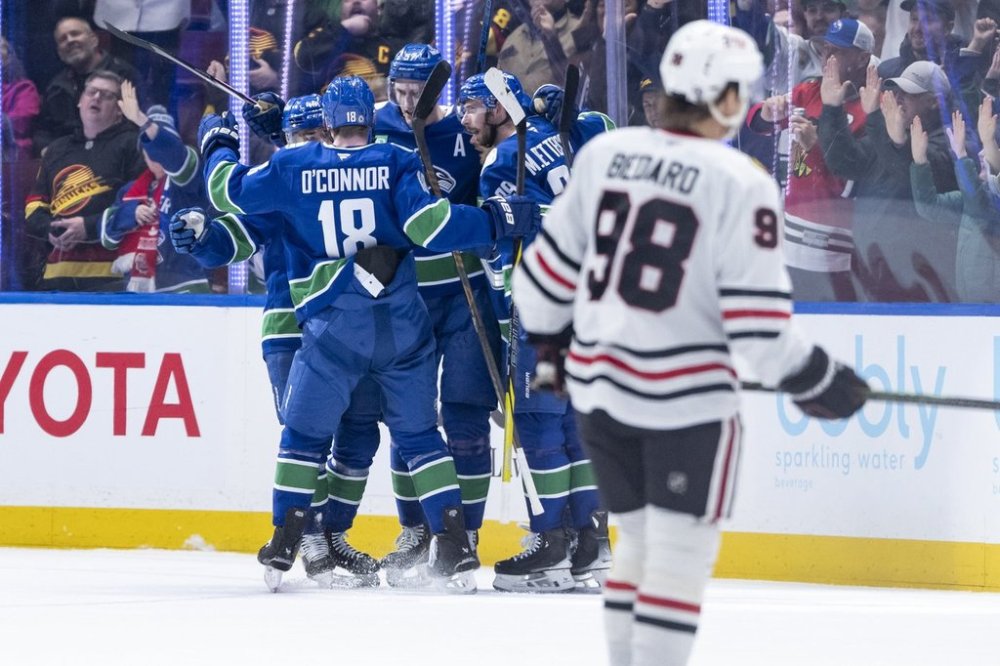 Vancouver Canucks' Tyler Myers (57) celebrates his goal with Kiefer Sherwood (44), Drew O'Connor (18), and Marcus Pettersson (29) as Chicago Blackhawks' Connor Bedard (98) skates back to the bench during the first period of an NHL hockey game in Vancouver, B.C., on Saturday, March 15, 2025. THE CANADIAN PRESS/Ethan Cairns