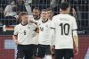 Germany's Joshua Kimmich, left, celebrates with teammates after scoring opening goal during the Nations League quarterfinal second leg soccer match between Germany and Italy at the Signal-Iduna Park in Dortmund, Germany, Sunday, March 23, 2025. (AP Photo/Martin Meissner)