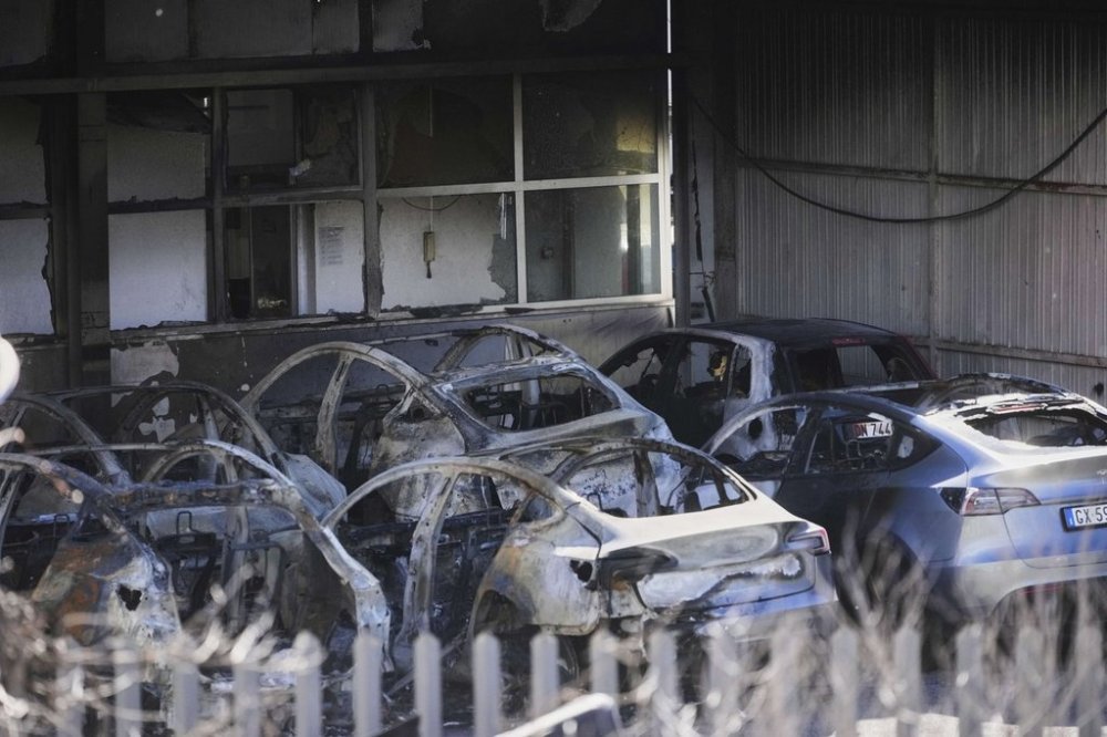 Burned Tesla cars are seen at a dealership on the outskirts of Rome, Monday, March 31, 2025. (AP Photo/Alessandra Tarantino)