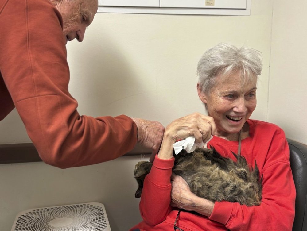 In this image provided by Carolyn Kiefer her mother, Katherine Kiefer, 82, is reunited with her cat Aggie at VCA Chatoak Animal Hospital after the Palisades Fire destroyed her home and the cat was missing, Saturday, March 8, 2025, in Los Angeles. (Carolyn Kiefer via AP)