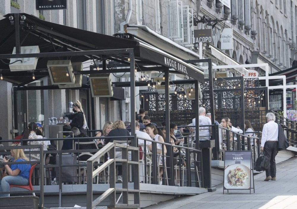 People enjoy the warm weather and dine on a terrace in Montreal, May 12, 2022. The Quebec government says it's drafting a regulation to allow restaurants to charge people who reserve a table but don't show up and don't cancel ahead of time. THE CANADIAN PRESS/Ryan Remiorz