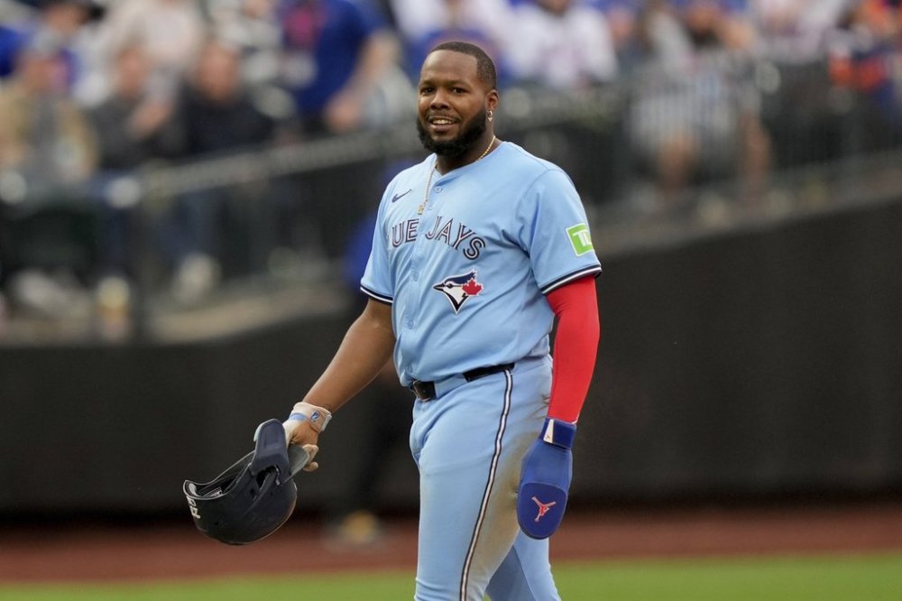 Toronto Blue Jays slugger Vladimir Guerrero Jr. (27) smiles after being tagged at second base by New York Mets shortstop Francisco Lindor (12) during the eighth inning of a baseball game on April 4, 2025, in New York. (AP Photo/Julia Demaree Nikhinson)