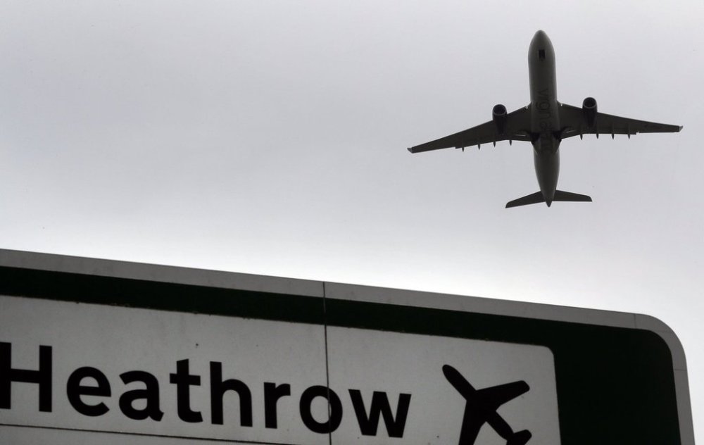 FILE - A plane takes off over a road sign near Heathrow Airport in London, June 5, 2018. (AP Photo/Kirsty Wigglesworth, File)