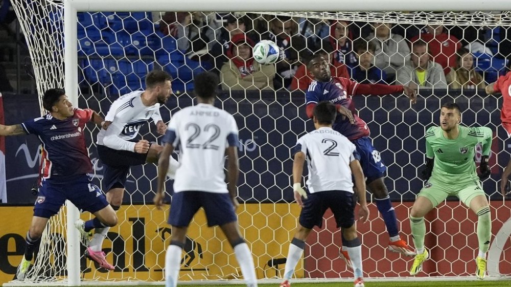 Vancouver Whitecaps defender Tristan Blackmon, second from left, scores a goal against FC Dallas defenders Shaq Moore (18), Marco Farfan (4) and goalkeeper Maarten Paes (1) during second-half MLS soccer match action in Frisco, Texas, Saturday, March 15, 2025. (AP Photo/LM Otero)