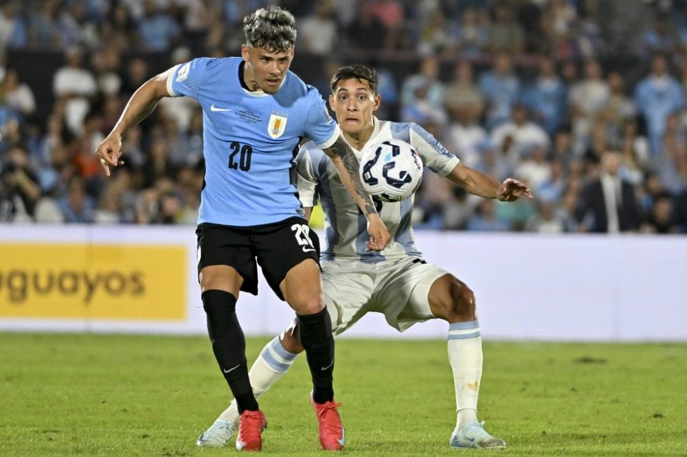 Uruguay's Maximiliano Araujo, left, and Argentina's Nahuel Molina battle for the ball during a qualifying soccer match for the FIFA World Cup 2026 in Montevideo, Uruguay, Friday, March 21, 2025. (AP Photo/Santiago Mazzarovich)