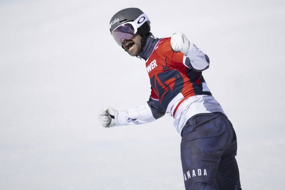 Eliot Grondin of Canada takes the win during the Snowboard cross competition at the FIS Snowboard, Freestyle and Freeski World Championships on Friday, March 28, 2025, in St. Moritz, Switzerland. (Gian Ehrenzeller/Keystone via AP)